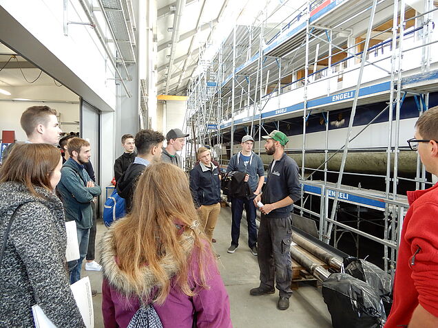 Visite du chantier naval: Les participants écoutent Matthias Enzler, marin et employé du chantier naval de SBS.